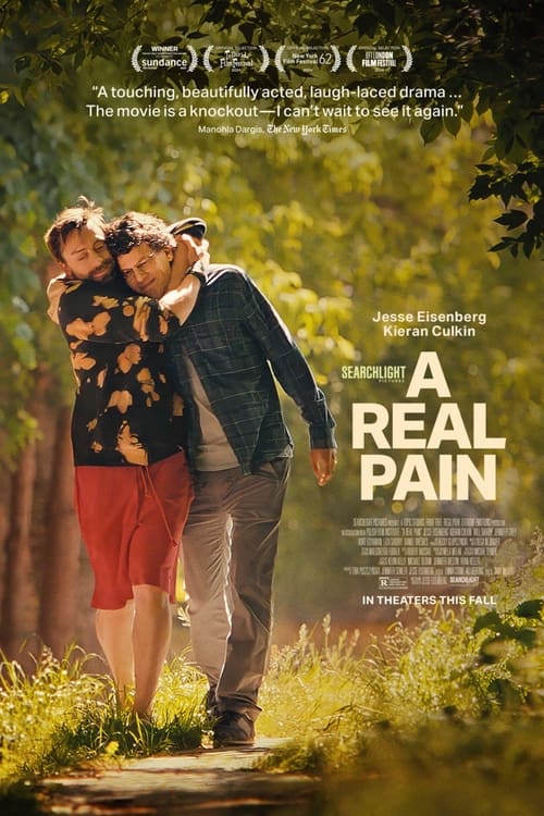 A Real Pain (2024) - Movie Poster. The movie poster features two individuals, one wearing a black shirt with orange and yellow patterns and red shorts, and the other in a plaid shirt and gray pants, walking arm in arm through a lush, green forest. The background is filled with vibrant greenery, suggesting a serene and natural setting. At the top of the poster, there are accolades from the Sundance Film Festival and other film festivals, indicating the film's critical acclaim. The title "A Real Pain" is prominently displayed in bold, white letters, with the names "Jesse Eisenberg" and "Kieran Culkin" listed below it. The poster also includes a tagline that reads, "A touching, beautifully acted, laugh-laced drama... The movie is a knockout—I can't wait to see it again." The bottom of the poster mentions that the film is in theaters this fall.