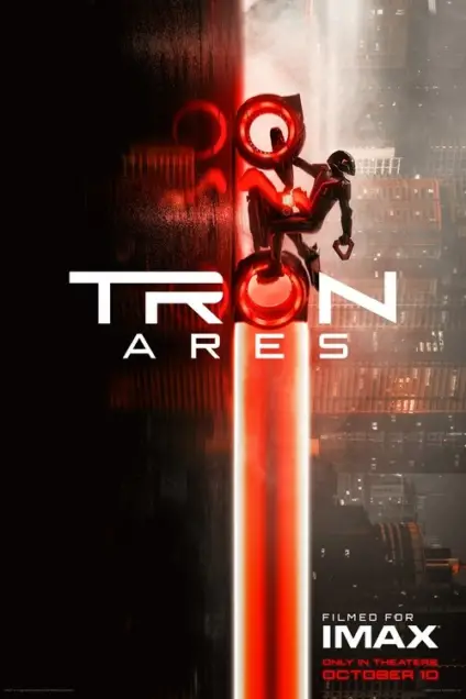 Tron: Ares (2025) - Movie Poster. The movie poster features a striking visual of a futuristic cityscape with a dark, industrial aesthetic. The title "TRON: ARES" is prominently displayed in bold, white letters, with the word "TRON" in a larger font and "ARES" below it. A central figure, clad in futuristic armor, is suspended in mid-air, seemingly in a dynamic pose, with a glowing red light emanating from their body. The background is a mix of dark, smoky tones and bright, contrasting lights, creating a sense of depth and intensity. The bottom of the poster includes text indicating that the film is "Filmed for IMAX" and "Only in Theaters October 10," suggesting a release date and the exclusive nature of the viewing experience.