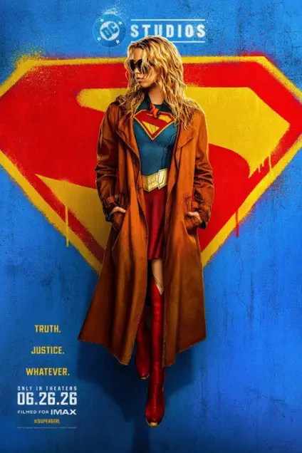 Supergirl (2026) - Movie Poster. The movie poster features a character standing confidently with hands in pockets, wearing a brown trench coat over a blue and red superhero suit with a large "S" emblem on the chest. The background is a vibrant blue with a large, stylized yellow and red "S" emblem behind the character. The text on the poster reads "Truth. Justice. Whatever." at the bottom, and "DC STUDIOS" at the top. The release date is indicated as "06.26.26" and it is noted that the film is "Filmed for IMAX." The hashtag "#SUPERGIRL" is also present.